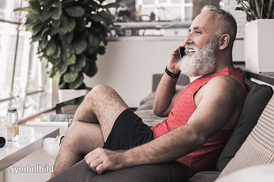Mann telefoniert entspannt sitzend.
